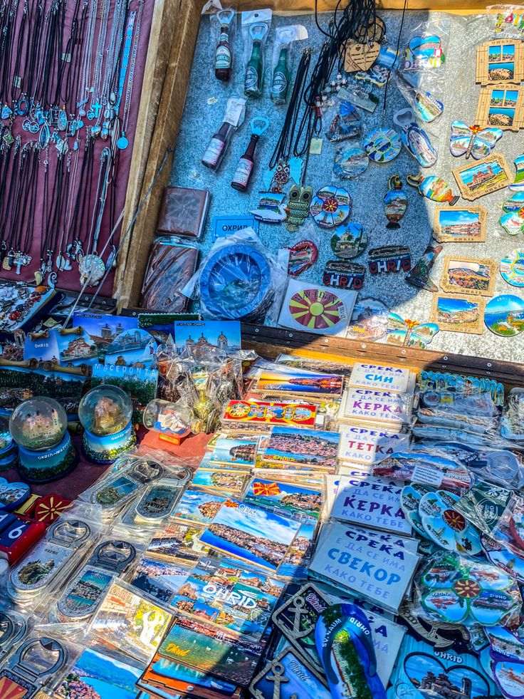 there are many different items on display in this market stall, including brooches and necklaces