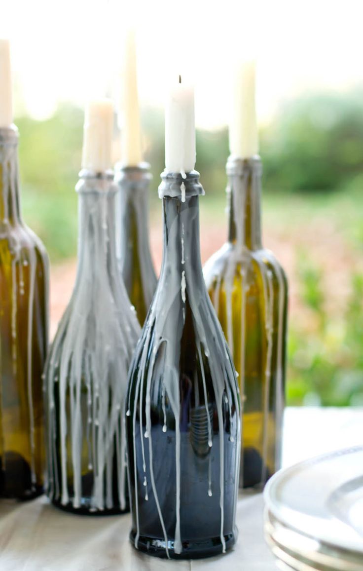 several bottles with candles in them sitting on a table