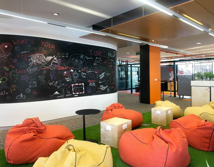 an office with bean bags on the floor and chalkboard in the wall behind it