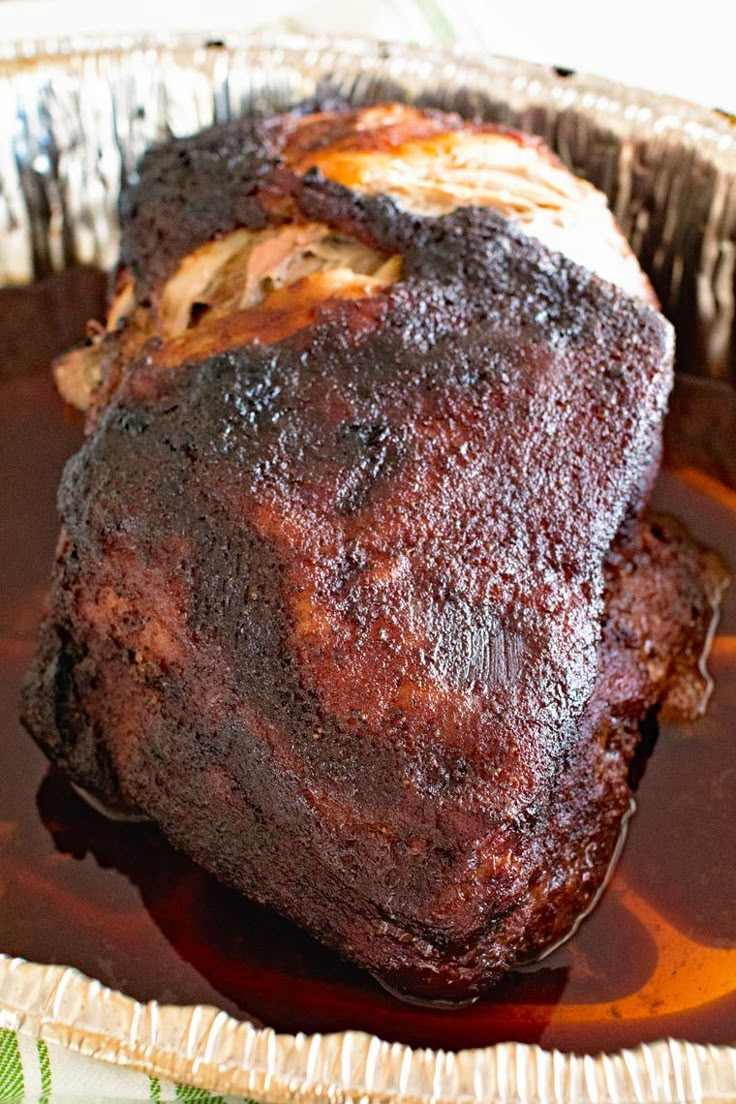 a piece of meat sitting on top of a pan covered in sauce