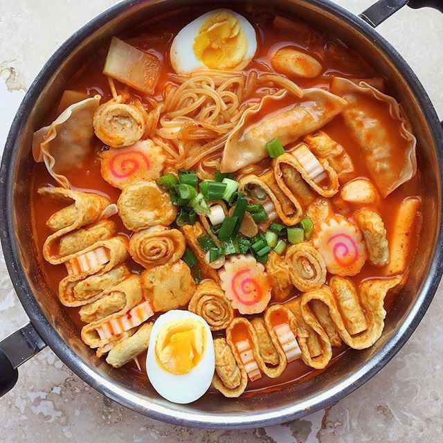 a bowl filled with noodles and vegetables next to an egg