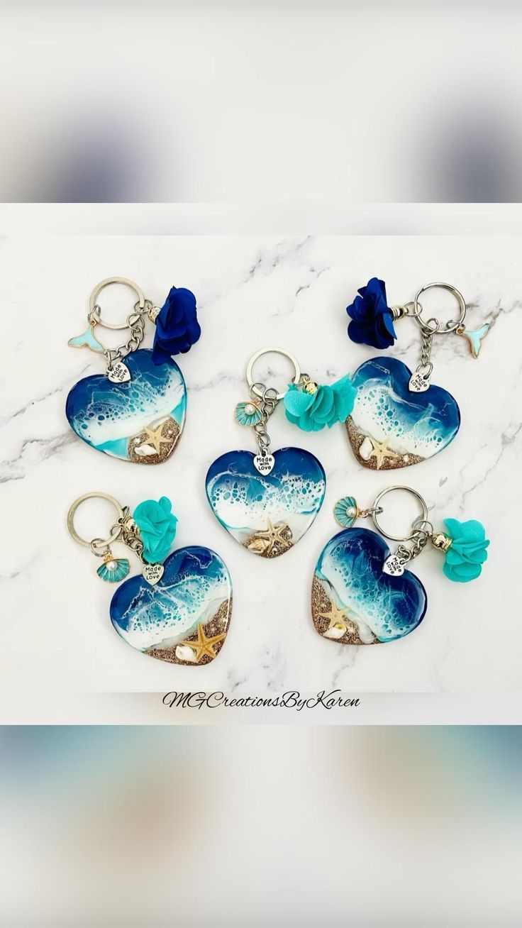 six heart shaped key chains with blue and white designs on them sitting on a marble surface