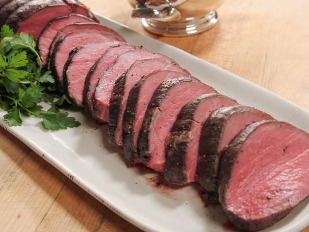 sliced meat and parsley on a white plate