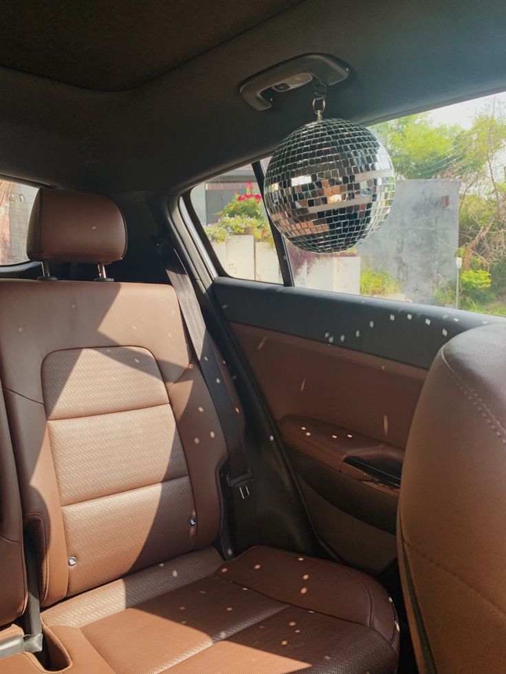 the interior of a car with a disco ball hanging from the ceiling