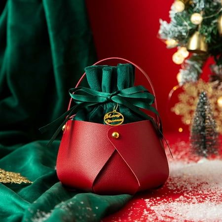 a red purse sitting on top of a table next to a christmas tree and decorations