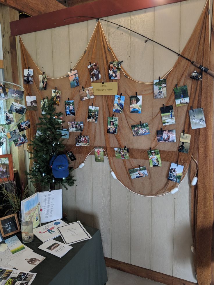 a table with pictures and photos hanging on the wall next to a potted plant