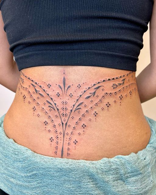 a woman's stomach with an intricate design on the bottom and lower back side