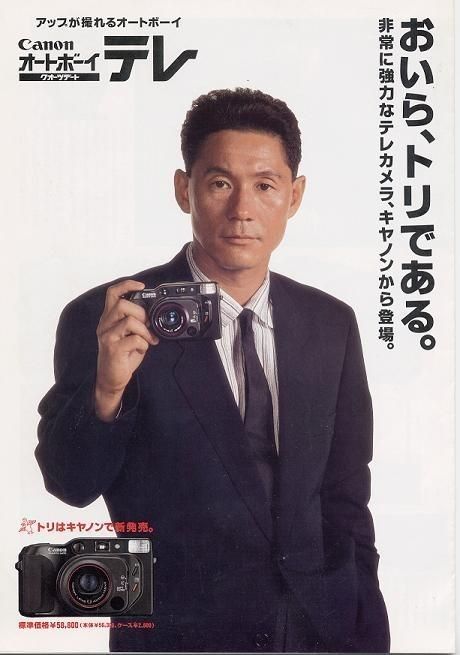 a man in a suit holding up a camera