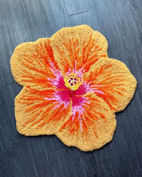 an orange and pink flower on a wooden floor