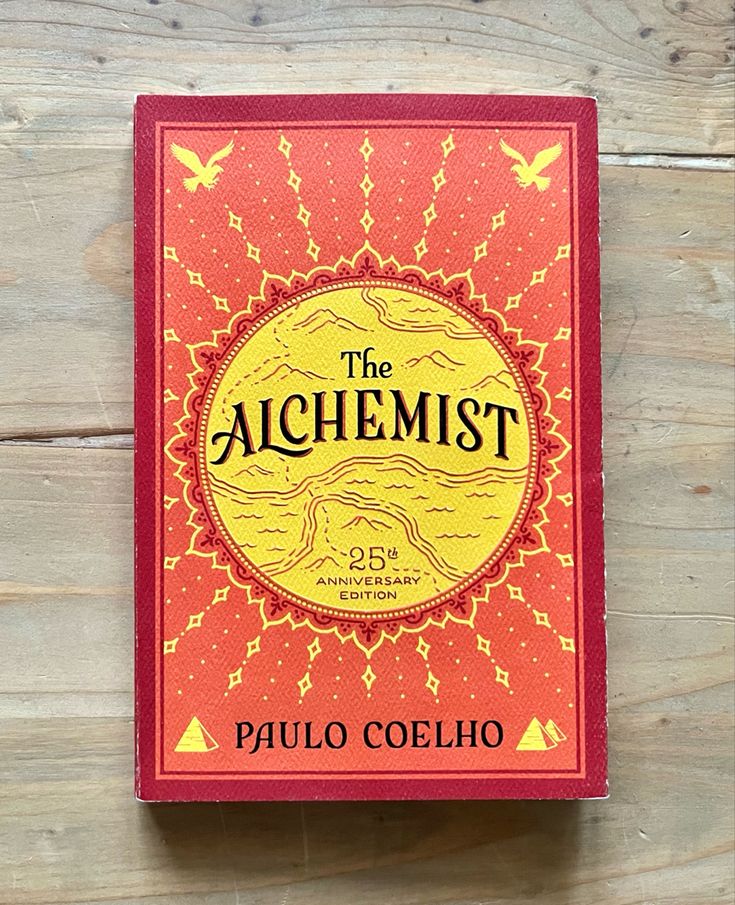 the alchemist by paul coelhoo on a wooden table with wood planks