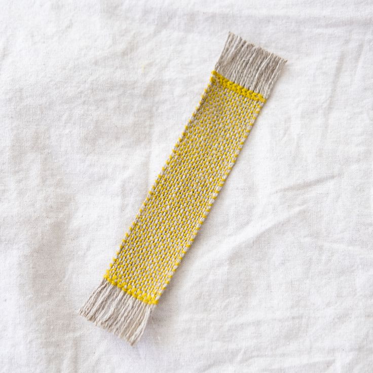 a yellow and white piece of cloth on top of a table