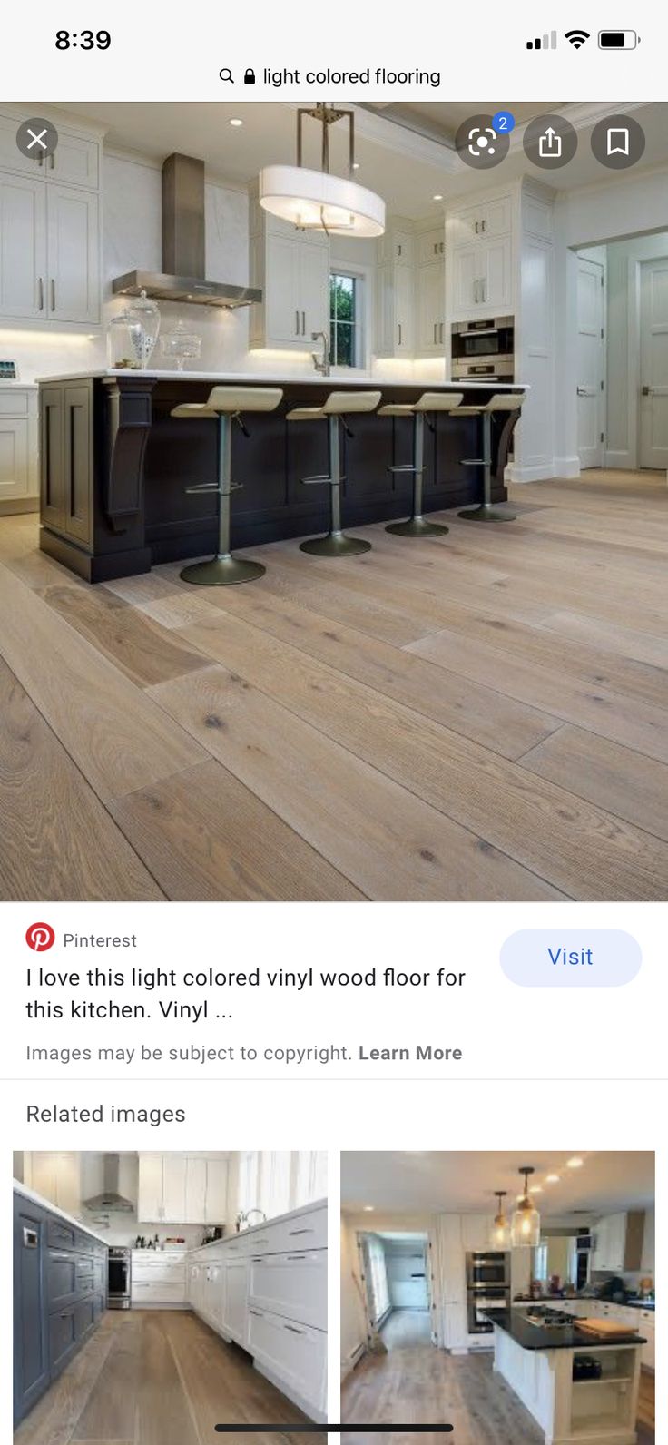 an image of a kitchen with white cabinets and wood flooring on the bottom right