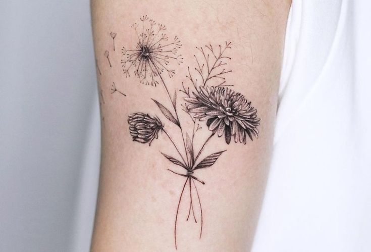 a black and white photo of flowers on the right arm, with dandelions in the background