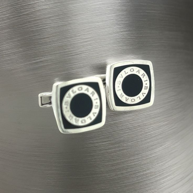 Bulgari Bvlgari Estate Onyx Cufflinks Silver B7TRUSTED SELLER SINCE 2002PLEASE SEE OUR HUNDREDS OF POSITIVE FEEDBACKS FROM OUR CLIENTS!!FREE SHIPPINGDETAILSMaterial: Onyx and Sterling SilverWeight: 18 Grams Introducing the quintessence of luxury and design - the authentic Bulgari Bvlgari sterling silver cufflinks. These exquisite cufflinks are a testament to Bulgari’s renowned craftsmanship and timeless elegance. Crafted from premium sterling silver, they feature the iconic Bulgari Bvlgari logo, Luxury Black Cufflinks For Formal Occasions, Black Luxury Cufflinks For Formal Occasions, Black Luxury Cufflinks For Formal Wear, Luxury Black Formal Cufflinks, Designer White Gold Cufflinks For Formal Occasions, Luxury Black Enamel Jewelry For Formal Occasions, Black Clip-on Jewelry For Formal Occasions, Elegant Hallmarked White Gold Cufflinks, Designer Silver Cufflinks With Polished Finish