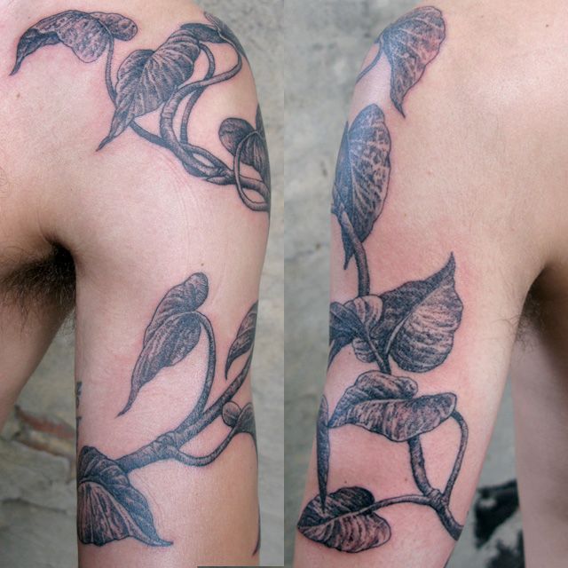 two tattoos on the arms of men with flowers and leaves tattooed on their arm sleeves