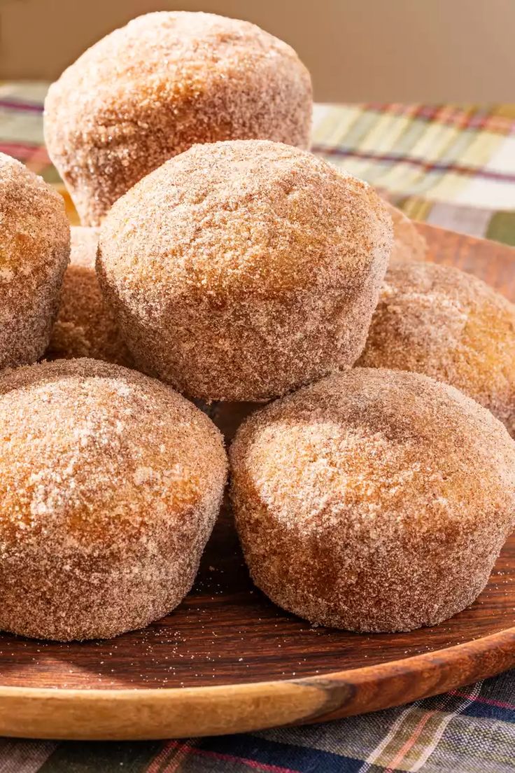 several sugary muffins on a wooden plate