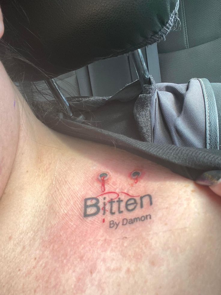 a woman with a tattoo on her chest saying, bitten by danon is shown