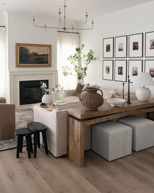 a living room filled with furniture and pictures on the wall above it's fireplace