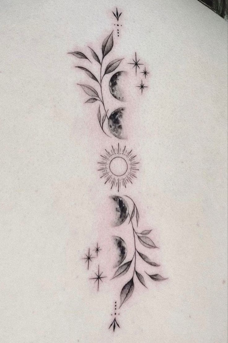 the back of a woman's neck with phases and stars tattoo on her left side