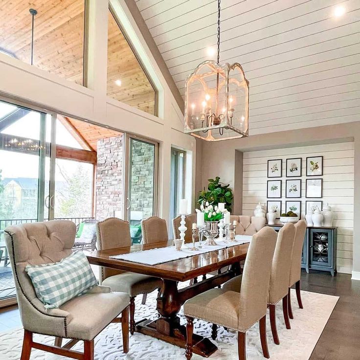 a large dining room table with chairs and chandelier hanging from it's ceiling