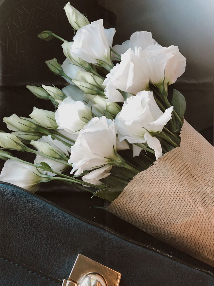 white flowers sitting on top of a black bag