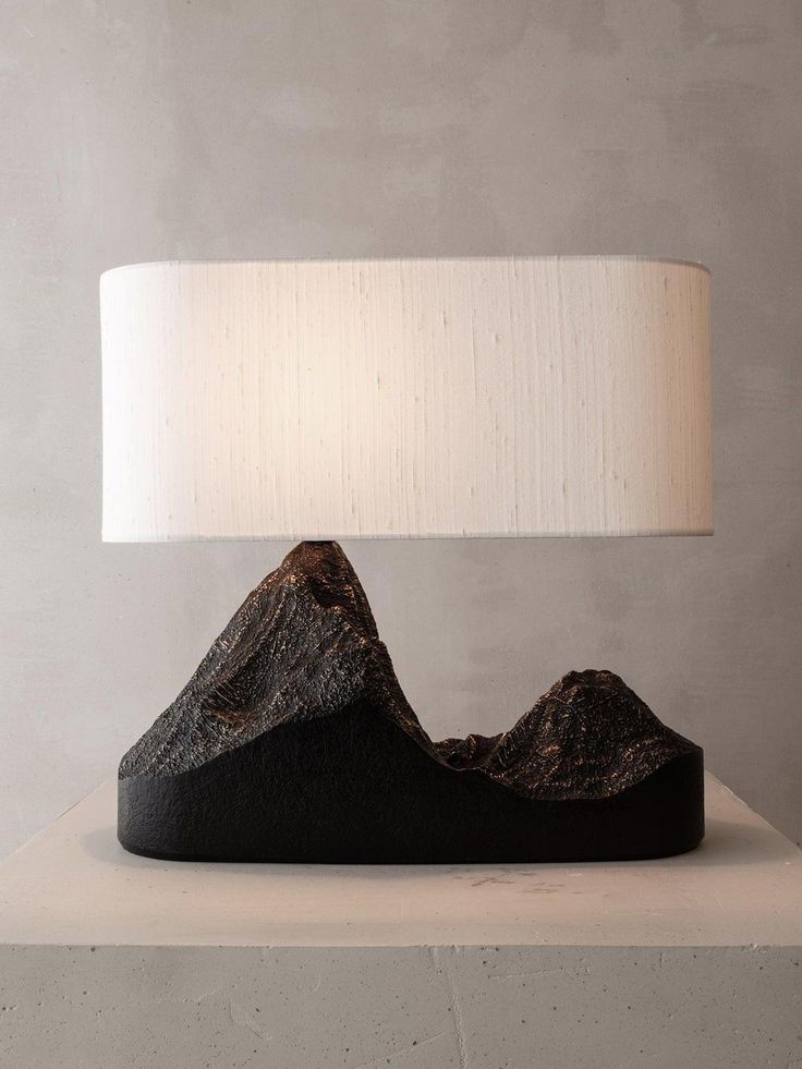 a lamp that is sitting on top of a table in front of a stone wall