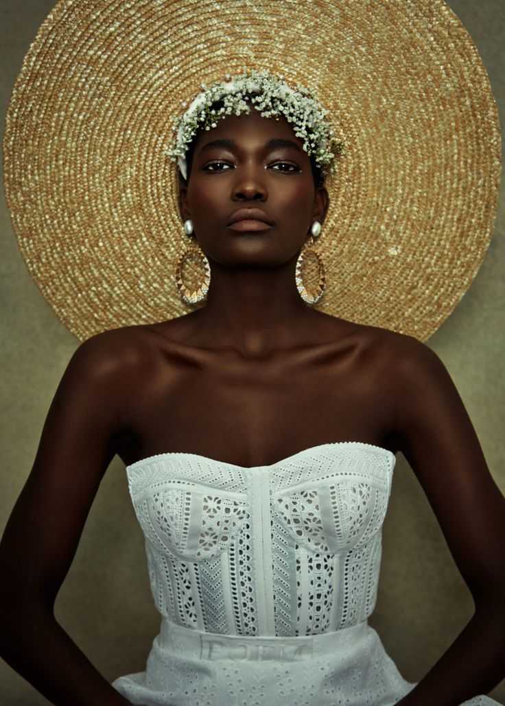 a woman wearing a straw hat and white dress