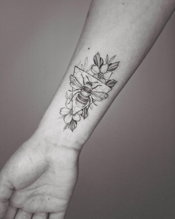 a woman's arm with a flower tattoo on it