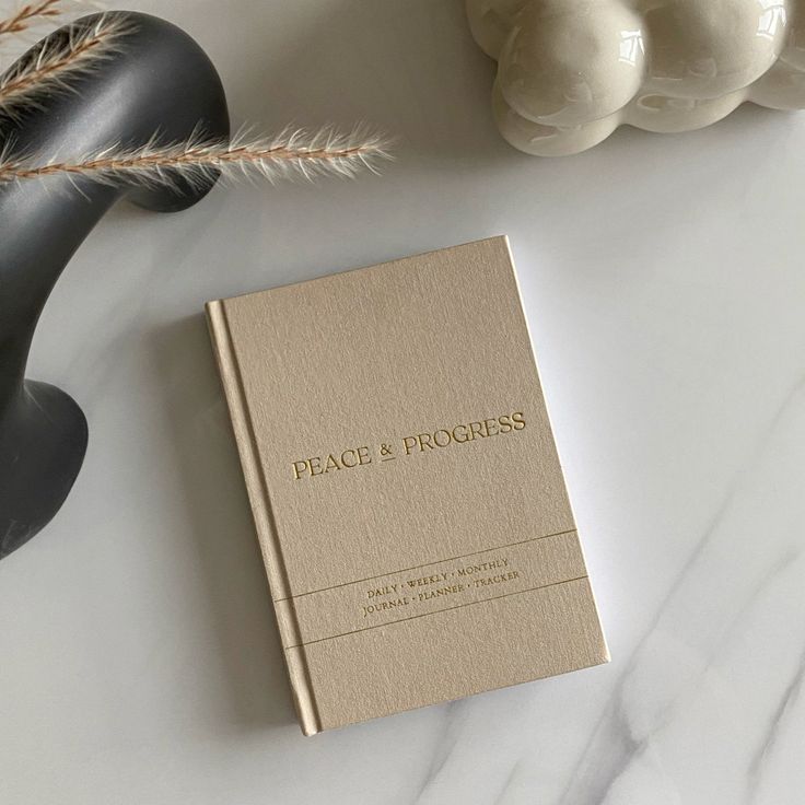 a book sitting on top of a white table next to some flowers and other items