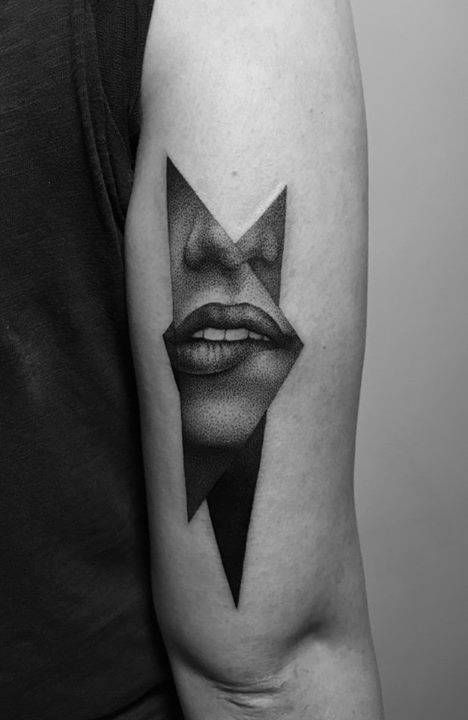 a woman's face with an arrow tattoo on her arm