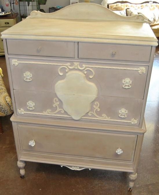 an old dresser is painted white and has ornate designs on it