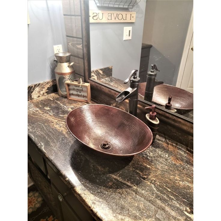 a bathroom sink sitting on top of a wooden counter