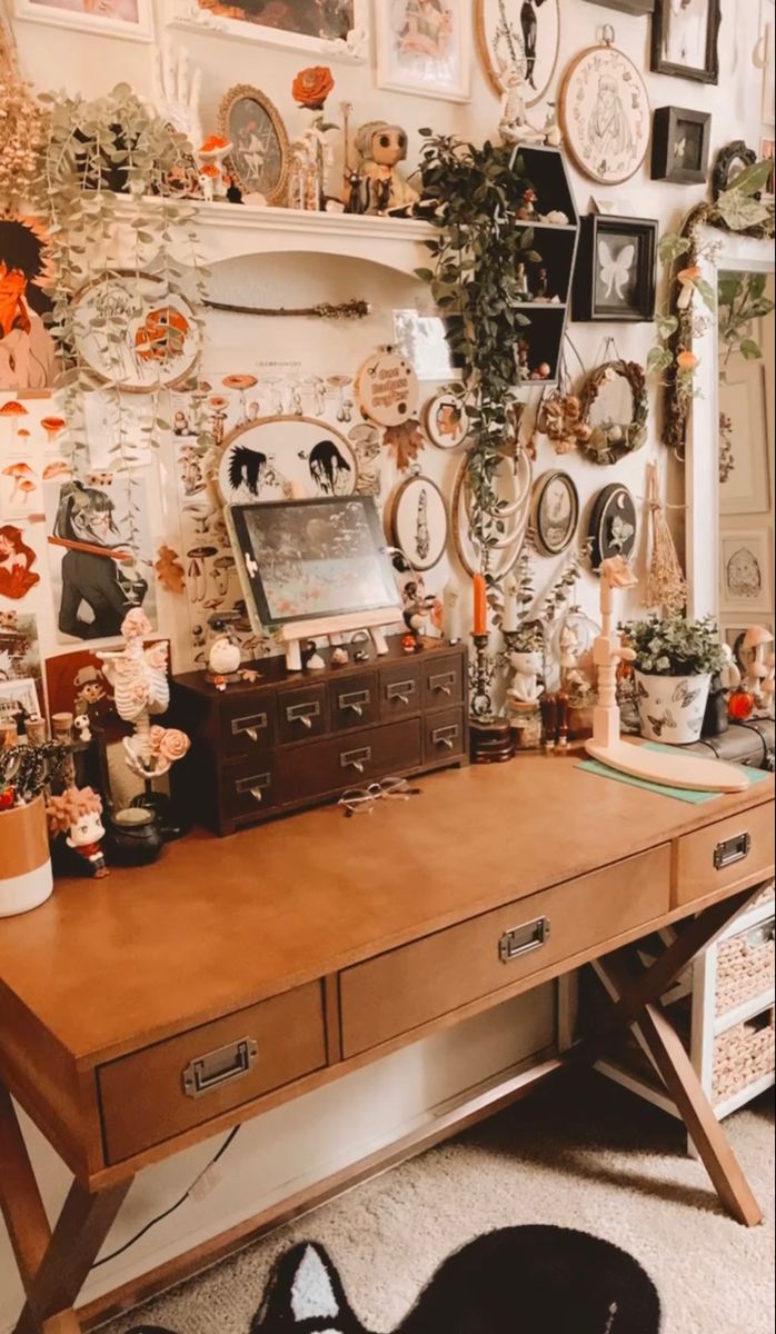 a wooden desk topped with lots of pictures and plants next to a wall covered in clocks