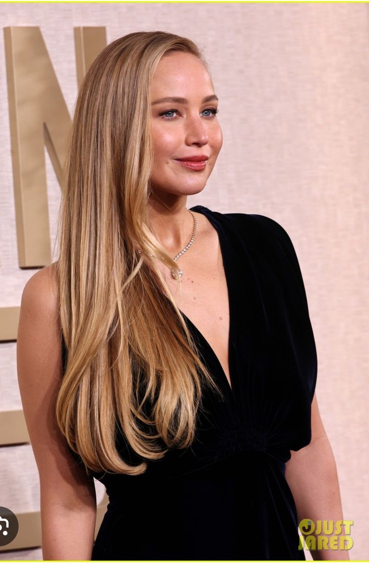 a woman with long blonde hair wearing a black dress