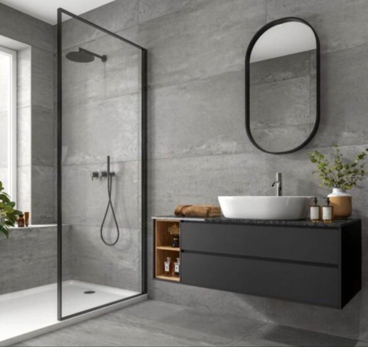 a bathroom with a sink, mirror and bathtub in grey color scheme on the wall