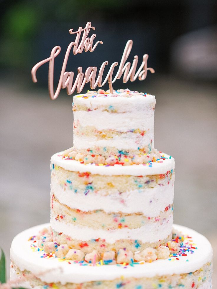 a three tiered cake with sprinkles and the words this taraschis on top