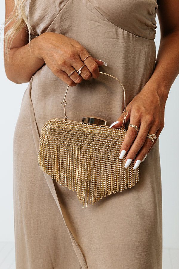 A glamorous essential, our pretty gold 'Champagne Life' clutch features shimmering rhinestone tassel detailing, a single metal handle, and a structured fully lined interior with a pressure snap closure! Gold Clutch Bag, Gold Purse, Rhinestone Clutch, Gold Clutch, Outfits Petite, Gold Champagne, Impressions Online Boutique, Current Fashion, 2022 Trends