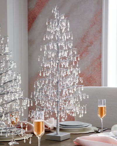 a table set with champagne glasses and a silver christmas tree