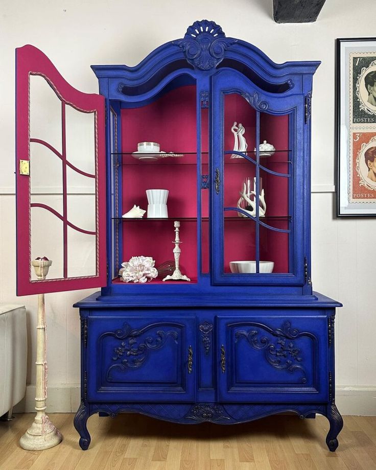 a blue china cabinet in a room with pink walls