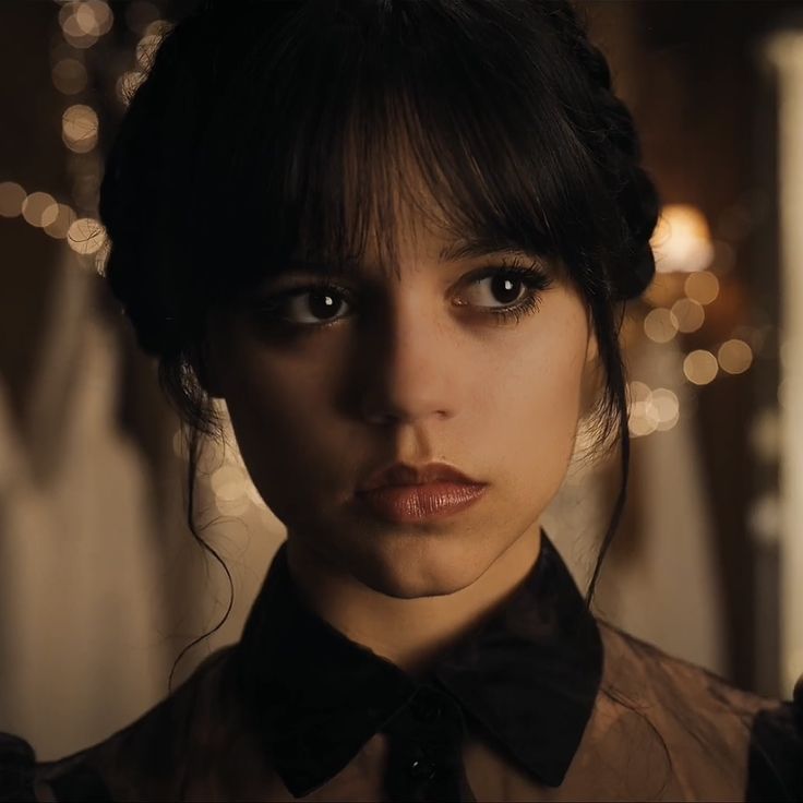 a close up of a person wearing a shirt and bow tie with lights in the background