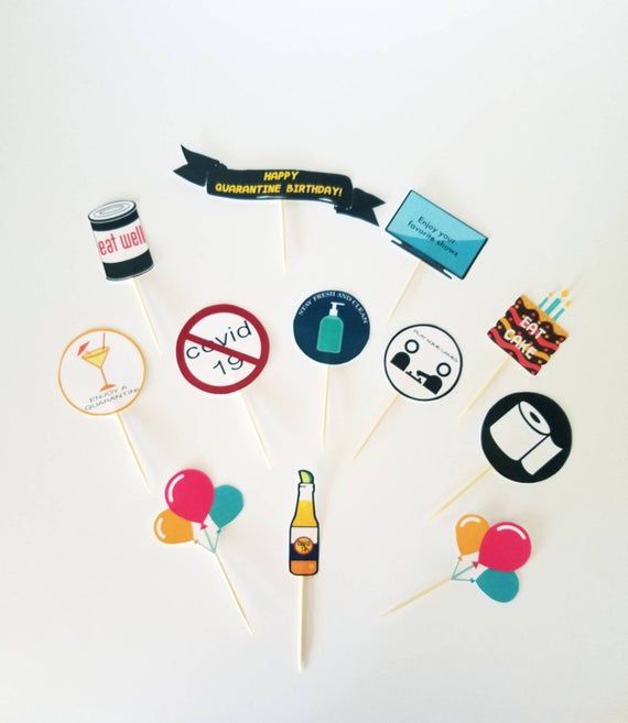 there are many cupcake toppers on the stick with some drinks and balloons around them