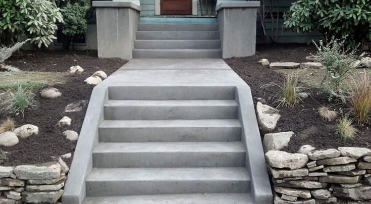 concrete steps lead up to the front door of a house