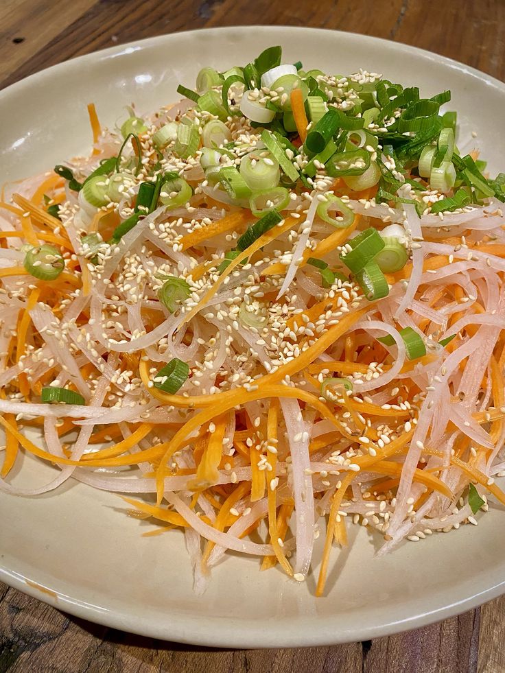 a white plate topped with lots of veggies on top of a wooden table