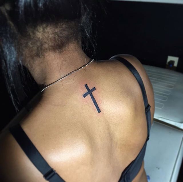 a woman with a cross tattoo on her back