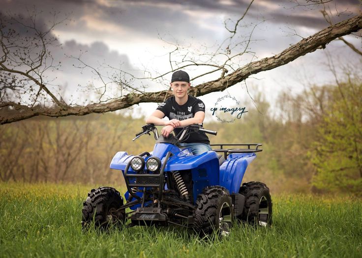 a boy is riding an atv in the grass