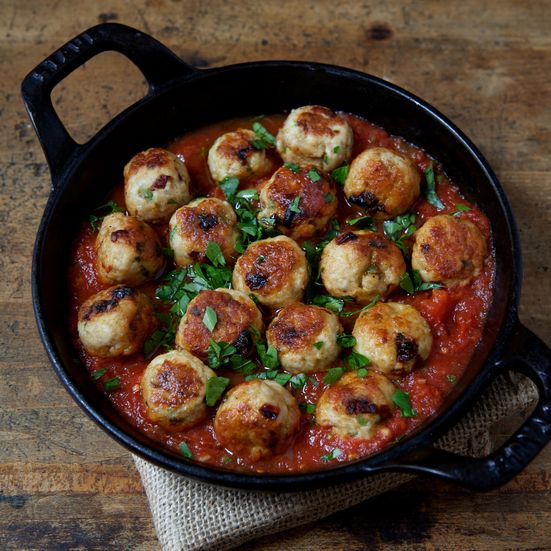 a skillet filled with meatballs covered in tomato sauce