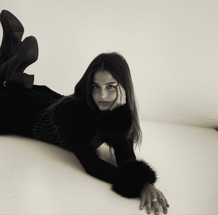 a black and white photo of a woman laying on the floor