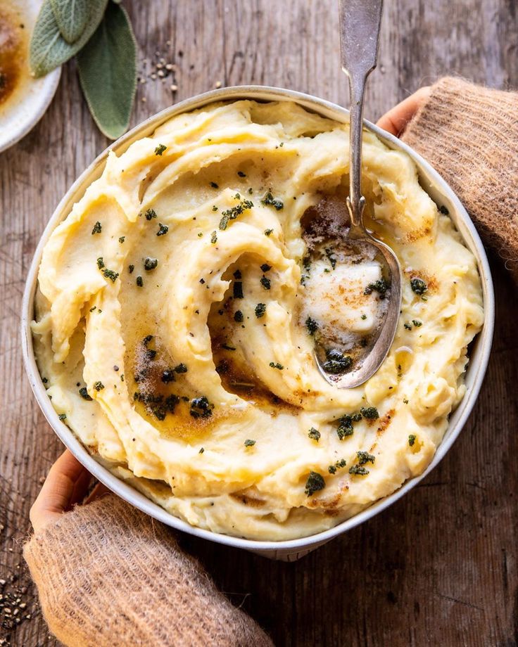 two hands holding a bowl of mashed potatoes