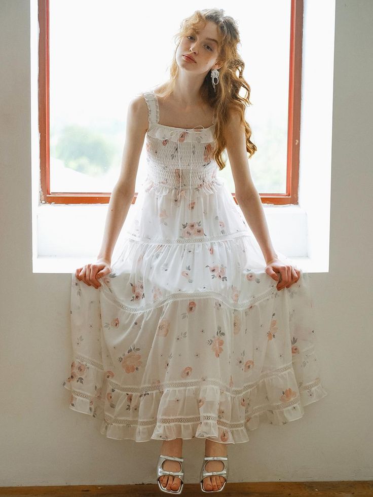 This product, the Cest Sweet Floral Slimming Dress, beautifully combines romantic floral patterns with a flattering silhouette. The dress features a fitted bodice with delicate straps and a flowing tiered skirt, creating an ethereal and feminine look. The intricate lace detailing adds a touch of elegance, making it perfect for both casual outings and special occasions. - This dress showcases a fitted bodice with delicate straps, enhancing its romantic appeal.- The tiered skirt flows gracefully, providing a flattering and slimming silhouette.- Intricate lace detailing adds sophistication and elegance to the overall design.- The floral pattern is charming and timeless, suitable for various events.- A handmade Cali medal decoration has been attached to the lower right side of the front p Delicate Sleeveless Dress With Fitted Bodice, Delicate Fitted Bodice Sleeveless Dresses, White Tiered Skirt Dress With Adjustable Straps, Feminine Floral Dress With Ruffled Straps For Garden Party, Delicate Summer Dress With Fitted Bodice, Delicate Ruffled Dress For Garden Party, Delicate Ruffled Garden Party Dress, Tiered Dress With Adjustable Straps For Garden Party, Tiered Garden Party Dress With Adjustable Straps