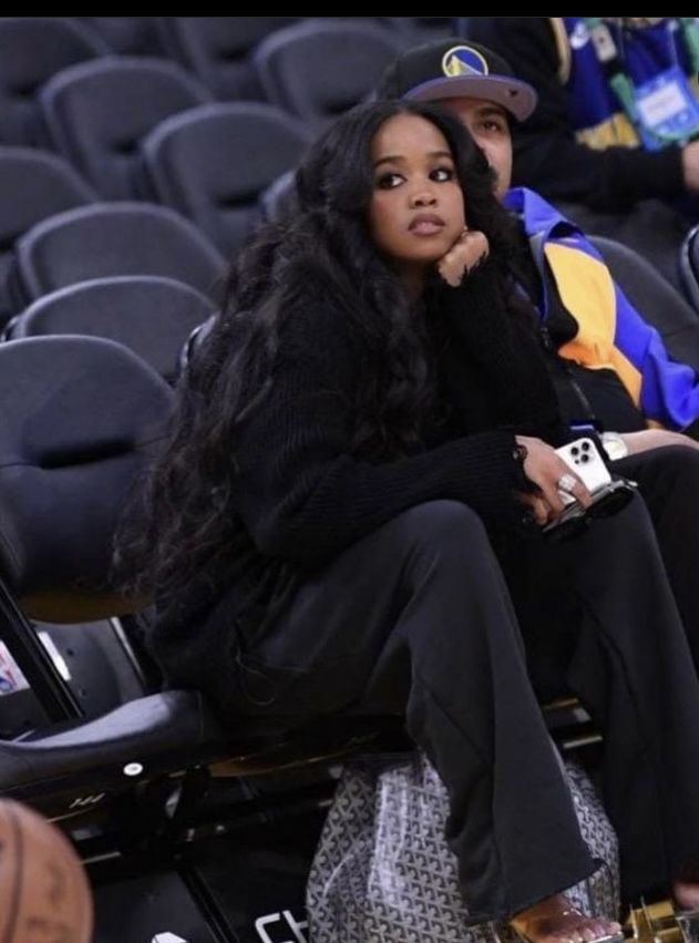 a woman sitting in the stands at a basketball game